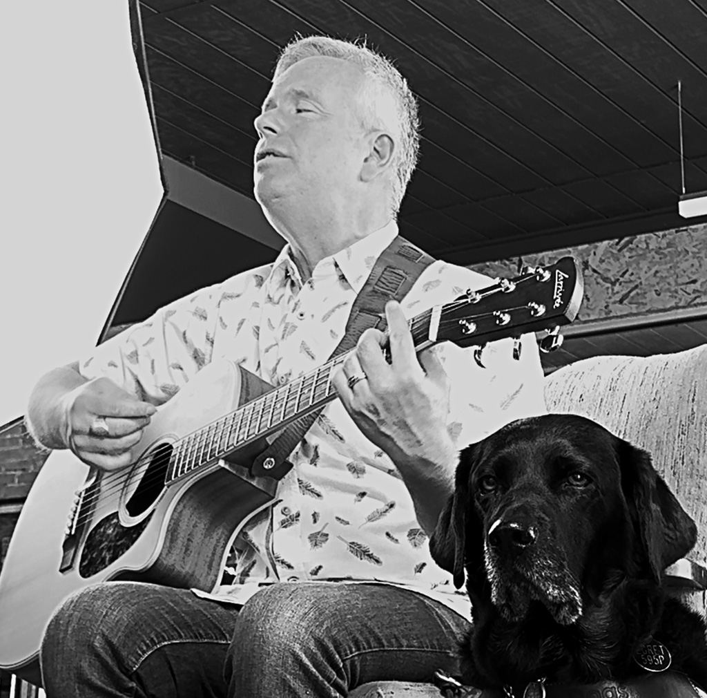 Rusty playing guitar next to a dog